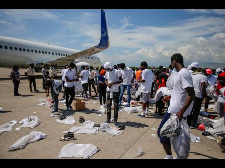 
Haitians deported from the United States recover their belongings scattered on the tarmac of the Toussaint Louverture airport in Port-au-Prince, Haiti, Tuesday, September 21. 