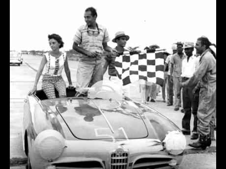 
In this Gleaner photograph, Richard Sirgany, with the chequered winner’s flag, stands beside his wife Yvonne in the Alfa Romeo he drove to victory in the 55-mile Jamaica Grand Prix at Vernam Field on September 24, 1961.


 
