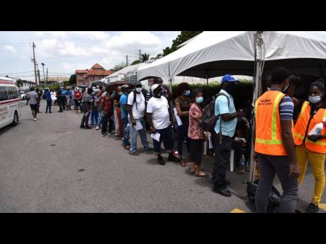 People waiting to receive the coronavirus vaccine at the Ministry of Health and Wellness’ mobile vaccination drive at Sovereign Centre in St Andrew last month.