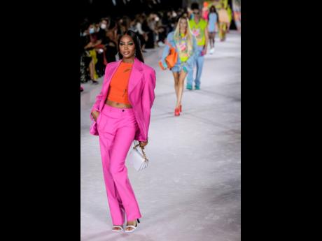 Jamaica-blooded supermodel Naomi Campbell wears a hot-pink suit and orange shirt for the Versace Spring/Summer 2022 collection during Milan Fashion Week, in Italy, on Friday.