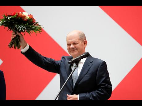 Olaf Scholz of the Social Democratic Party, top candidate for chancellor, holds a bunch of flowers after a press statement at the party’s headquarter in Berlin, Germany, yesterday.