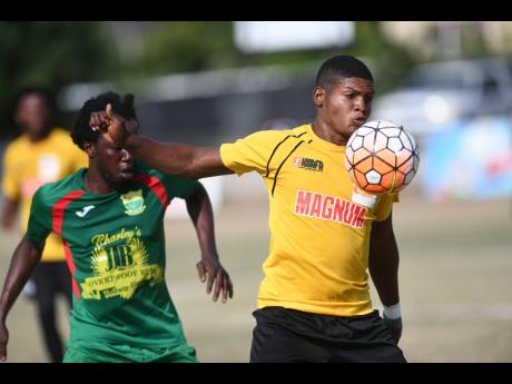 Wadadah defender Jamar Johnson (left) stays close to Barbican FC player Shaquille Lewis, trying to take the ball off him, during their Magnum/Charley’s JB Rum/Jamaica Football Federation Premier League playoff at the Barbican Sports Complex on Sunday, Ju