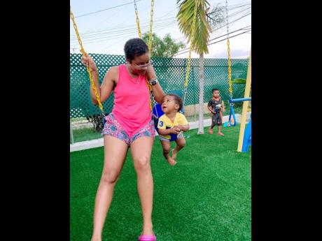 
Warrior Mom Tara Montaque thoroughly enjoys spending quality time with her sons. She is seen here swinging with Kyrie, while Yuri plays in the background. 