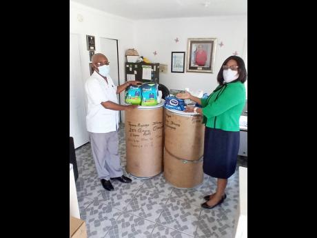 Principal of Bethel Primary School, Jasmin Johnson (right) makes a presentation of food, cleaning material and other items to Sydney Grant, interim manager of The West Haven Children’s Home in Lethe, Hanover.