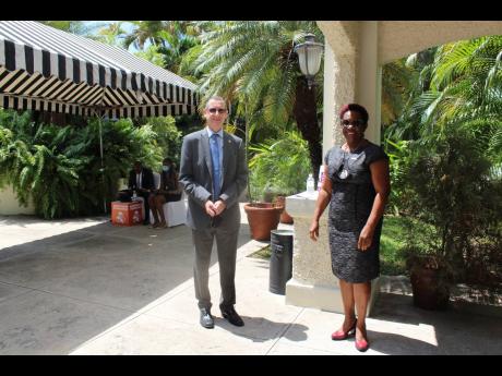 Jamaica Development Representative at the UK High Commission in Jamaica, Oliver Blake, and Principal Director of the Climate Change Division in the Ministry of Housing, Urban Renewal, Environment and Climate Change, UnaMay Gordon, greet each other at the r