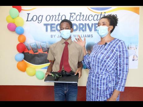 Dorrett Allen, mother of Glenmuir High School grade -0 student Bryan Sharpe, thanks Jaleel Williams, upper-sixth-form student, for the computer her son received. She shared the difficulty they had sharing her phone for him to attend classes and complete as