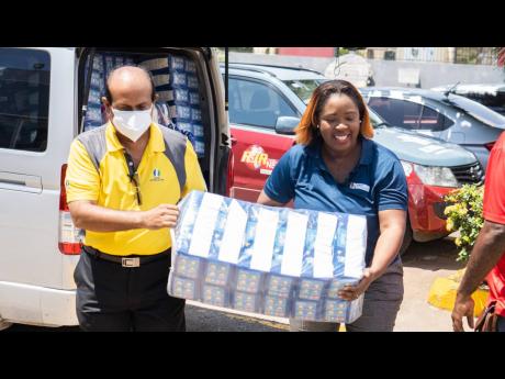 Massy Distribution Marketing and Corporate Communications Manager Patria-Kaye Charles and business partner V.C Dayanandan of Indus Life Sciences hand over the 89,000 diapers valued at $1.5 million.