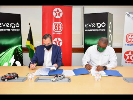 
CEO of GB Energy Texaco Jamaica, Bela Szabo (left) and Director, Strategic Planning, Facilities and IT at Jamaica Energy Partners, Kevin Francis, officially sign an agreement between both companies for the installation of electric vehicle chargers at a nu