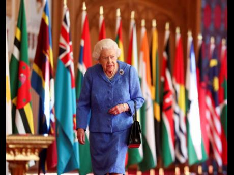 AP 
Britain’s Queen Elizabeth II walks past Commonwealth flags in St George’s Hall at Windsor Castle, England, to mark Commonwealth Day in this image that was issued on Saturday March 6, 2021.