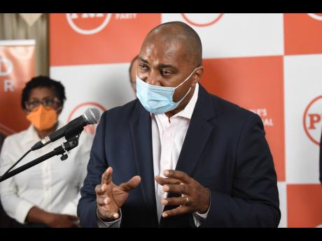 Julian Robinson, opposition spokesman on finance, addresses a press conference at the Office of the Leader of the Opposition on Monday. 