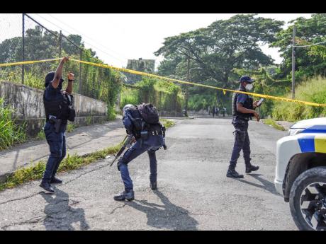 Policemen enter the cordoned area where Christopher 'Dog Paw' Linton was killed on Monday.