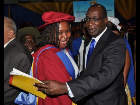 Dr Grace McLean gets a congratulatory hug from Ruel Reid as she graduated with her doctorate in philosophy on November 1, 2014. Reid resigned as education minister in 2019 and has been charged with corruption. The auditor general has called for a police in