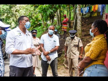 Nicholas Nunes/Photographer 
Prime Minister Andrew Holness (left) discussing the benefits of the COVID-19 vaccine with Trishana Jonas (right) in Scott Hall, St Mary, on Friday.