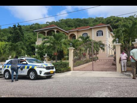 Police prepare to search the Coral Gardens, Montego Bay home of Dr Kevin O. Smith, the pastor of Pathways International Kingdom Restoration Ministries in Paradise, Montego Bay, St James. Smith was arrested on Sunday after a religious ritual that left two d