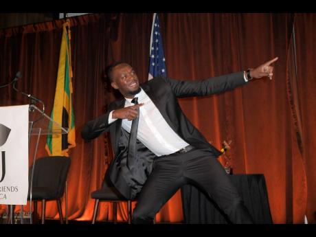 Usain Bolt makes his signature pose while collecting his award at the AFJ Award in NY.