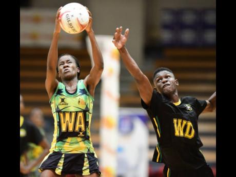 
Richard Hendricks (right) of Jamaica Men’s team fails to intercept a pass to Sunshine Girl Nicole Dixon-Rochester during last night’s  friendly match at the National Indoor Sports Centre in St Andrew.