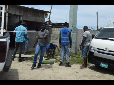A National Water Commission team disconnecting the supply to a delinquent customer at the Hellshire Beach in Portmore, St Catherine.