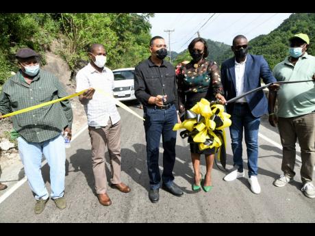 Prime Minister Andrew Holness (third left) and his wife Juliet Holness, member of Parliament for St Andrew East Rural, cut the ribbon to reopen the rehabilitated Gordon Town roadway yesterday with (from left) Caswell Whyte, project manager, National Works 