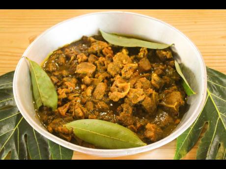 Curried goat garnished with green pimento leaves. 