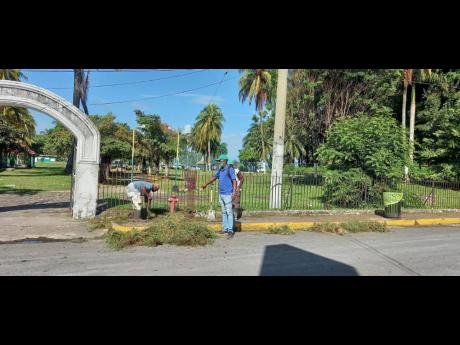 A crew cleans up an area near the West Harbour property next to Ken Wright Pier, ahead of Sunday’s cruise ship arrival in Port Antonio.