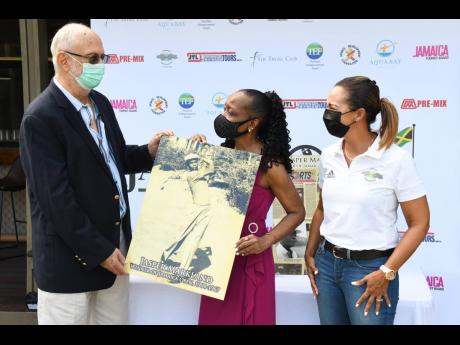 Jamaica Open Golf Championship tournament director, David Mais presents a photo of Jasper Markland to his daughter, Margaret, while JGA President Jodi Munn-Barrow looks on, at the launch event at the Constant Spring Golf Club yesterday.