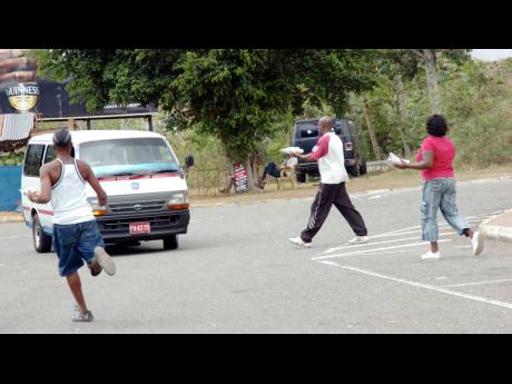 In this 2009 file photo, vendors at the Melrose Yam Park in Manchester rush towards an approaching vehicle in an attempt to get a sale.