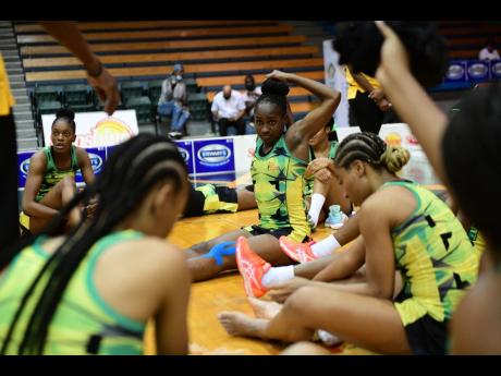 
Sunshine Girl Shannika Johnson (centre) adjusts her hair while the Jamaica team huddles during game two of the recent series against Trinidad and Tobago, at the National Indoor Sports Centre last month.