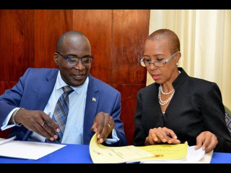 Former Education Minister Ruel Reid and current Education Minister Fayval Williams.