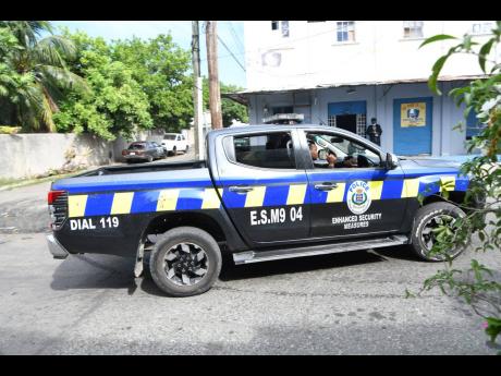 Police patrol a section of Franklyn Town on Sunday. A blanket state of emergency was imposed in all Kingston police divisions.