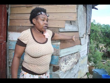 Althea Bryan of Palmer’s Cross, Clarendon, points to a section of the one-room structure that has deteriorated over time.