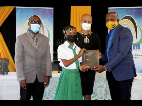 Clarendon South Eastern Member of Parliament Pearnel Charles Jr presents a tablet to Rhianna Morris of Green Park Primary School during a ceremony at the Clarendon-based institution yesterday. Looking on are Principal Michael Jackson (left) and Education M