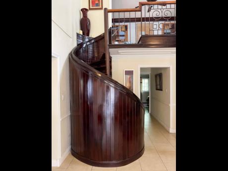 A metal spiral staircase enclosed in solid wood. 