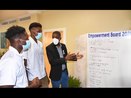 Motivational Speaker Sean Williams (right), engages with boys from the YWCA Vocational Centre, Robert Bonsfeather (centre) and Timothy Facey, during a youth of excellence empowerment forum at the Knutsford Court Hotel in New Kingston on November 17. 