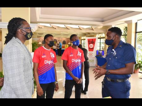 Acting District Officer, Jamaica Fire Brigade, Richard Guscott (right) and Policy Analyst (acting) and Focal Point for the Men and Masculinity Programme, Bureau of Gender Affairs, Nashan Miller (left), engaging with students of Camperdown High School, Dani