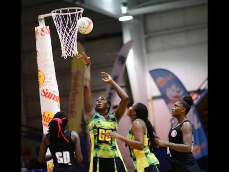 Jamaica’s senior netball captain and goalshooter, Jhaniele Fowler (second left), takes a shot during their tri-series match against Trinidad and Tobago’s Calypso Girls at the National Indoor Sports Centre last month.
