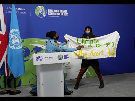 
A member of the security moves to apprehend a demonstrator at the COP26 UN Climate Summit in Glasgow, Scotland, on November 13, 2021. Almost 200 nations have accepted a contentious climate compromise aimed at keeping a key global warming target alive, but