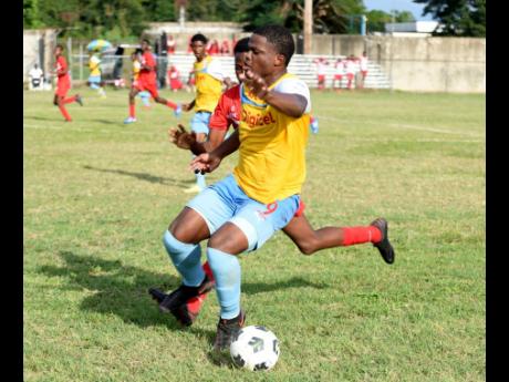
St George’s College’s Joshua Jackson comes under pressure from Odin Ranger of Bridgeport High School during the ISSA/Manning Cup football match at Spanish Town Prison Oval yesterday. St George’s College won 1-0.