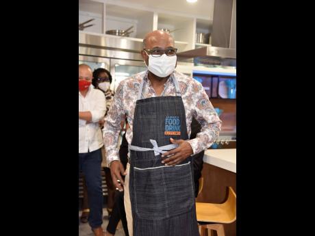 Tourism Minister Edmund Bartlett put on a branded apron for his cooking session with Chef Oji Jaja at the launch of the Jamaica Food and Drink Kitchen last Thursday. 