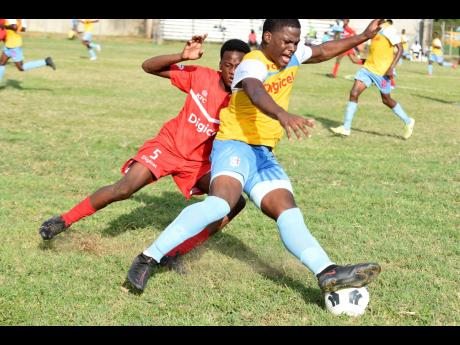 Bridgeport High School’s Odin Ranger (left) presses St George’s College’s Joshua Jackson during an ISSA/Digicel Manning Cup match at the Spanish Town Prison Oval in St Catherine on Saturday.