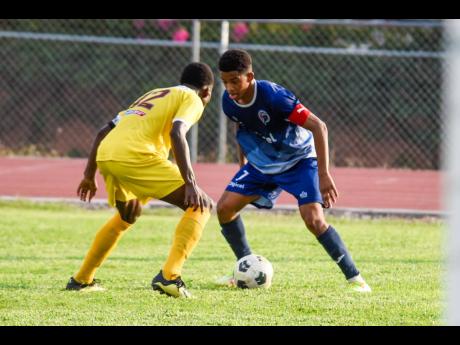 Duncan McKenzie of Jamaica College (right) tries to get around Kareem Griffiths of Charlie Smith High School during their ISSA/Digicel Manning Cup match held at Ashenheim Stadium in St Andrew on Saturday.