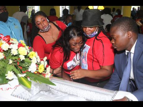 Tanesha Whyte is consoled by friends and relatives at the funeral service for three of the victims of the September 12 quadruple murder in Havannah Heights, Clarendon. Her sisters, Tashana Whyte and Sherona Whyte (25), and their nephew, Luke Newman, were b