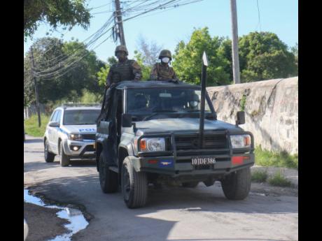 Members of the security forces patrol Ricketts Street in Savanna-la-Mar, Westmoreland, as part of operations under the state of emergency in the police division. The measure, which was also imposed in six other police divisions last week, failed to get the