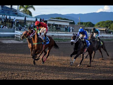 GOD OF LOVE (left), ridden by Robert Halledeen, wins the Gerry Skelton Memorial Trophy ahead of ONE DON (right), over five and a half furlongs at Caymanas Park in St Catherine yesterday.