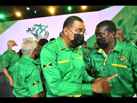 Jamaica Labour Party leader Andrew Holness (left) and Chairman Robert Montague are seen at the party’s 78th annual conference at the National Indoor Sports Centre on Sunday.