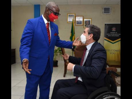 Desmond McKenzie (left), minister of local government and rural development, greets Jairo Raul Clopatofsky Ghisays, ambassador of the Republic of Colombia, during a courtesy call in Kingston on Tuesday.