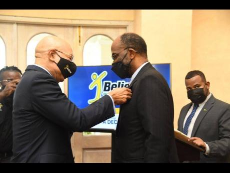 Governor General Sir Patrick Allen (left) pins Earl Jarrett, OJ, as an IBI Ambassador in a ceremony at King’s House on Tuesday.