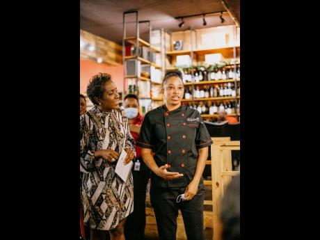 Debra Taylor-Smith, luxury portfolio manager of Select Brands, pays close attention as Uncorked Too’s Chef Shanner explains the meal.