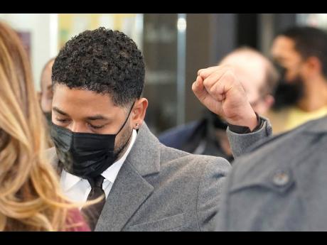 Actor Jussie Smollett raises his fist when asked how he was doing while walking through the Leighton Criminal Courthouse lobby on day four of his trial on Thursday. Smollett is accused of lying to police when he reported he was the victim of a racist, anti