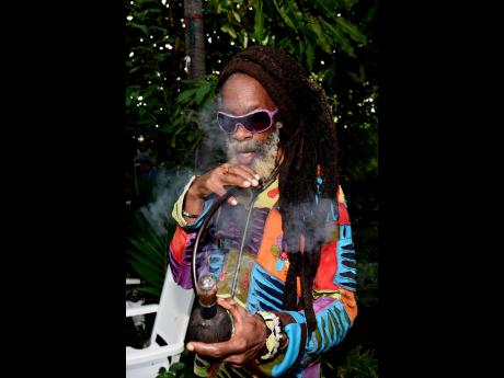 Reggae royalty, Earl ‘Chinna’ Smith, takes a hit of his chalice, as he speaks glowingly of his friend, Carlton ‘Pee Wee’ Fraser, at last Wednesday’s Groundation which he dedicated to his memory. 