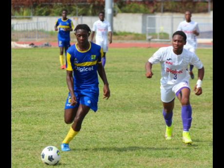 
Papine High School’s Jahmel Johnson (left) tries to outpace Kingston College defender, Khalifah Richards, during their ISSA/Digicel Manning Cup football encounter at Ashenheim Stadium, Jamaica College, on Friday. KC won 5-0.